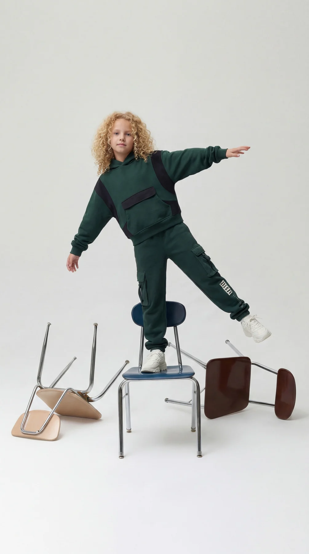 Children fashion portrait balancing on a chair