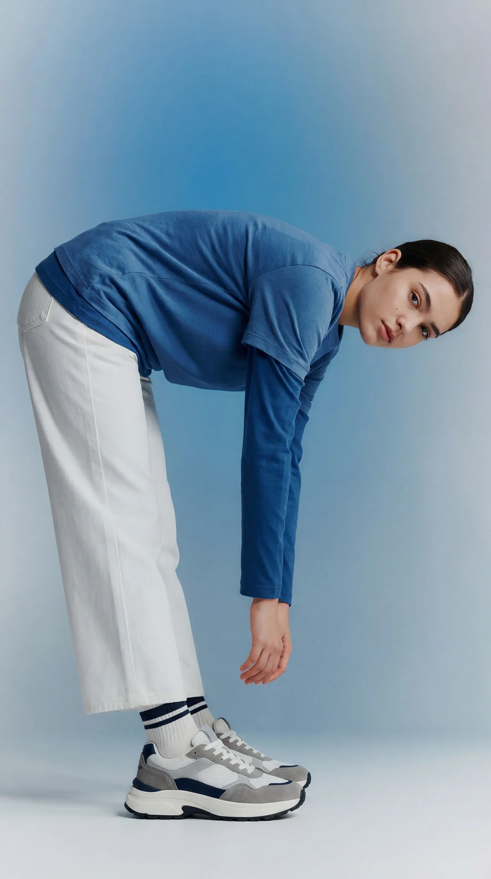 Blue and white studio fashion portrait with sneakers